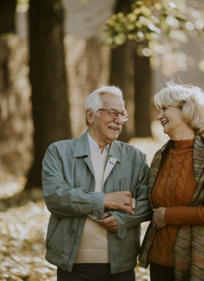 Handsome senior couple walking in autumn park